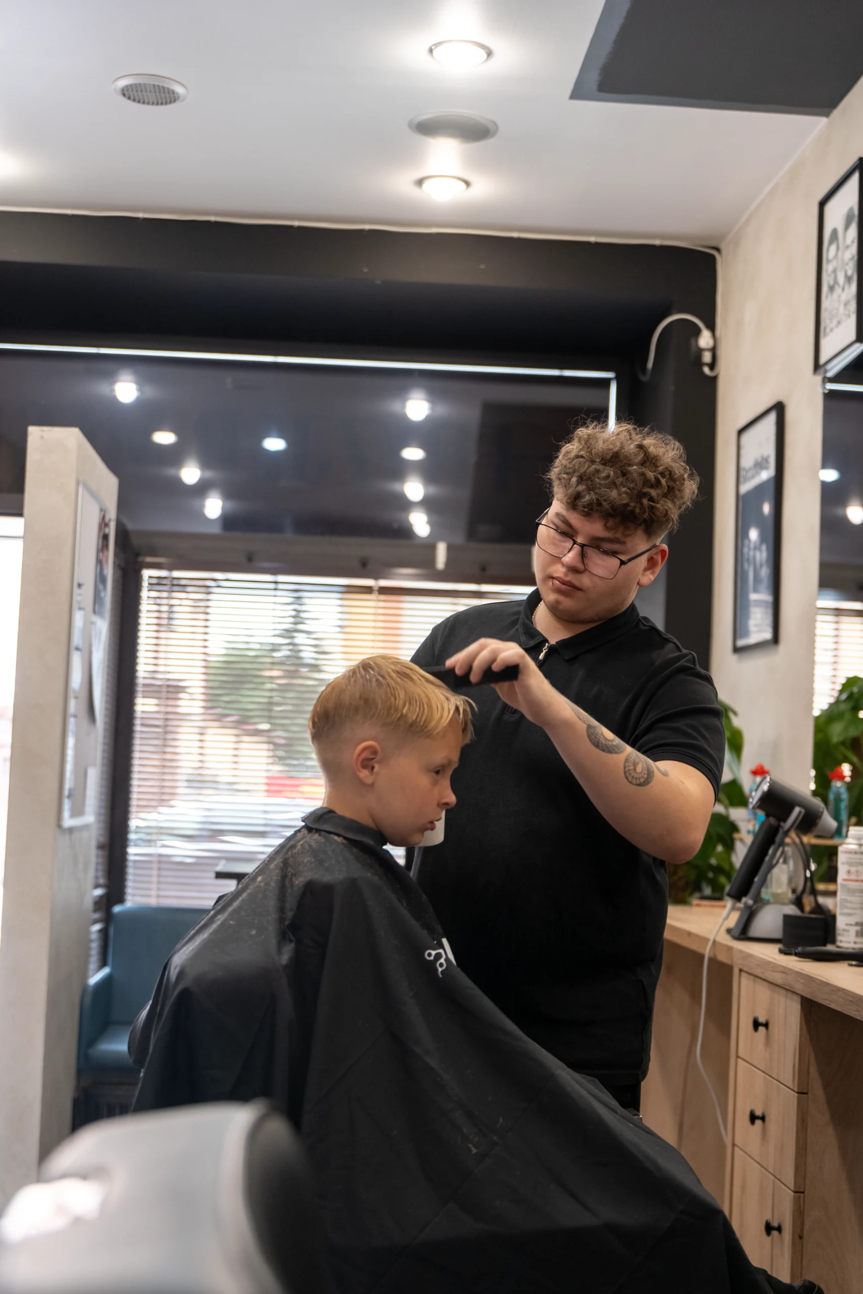 Barber strzyże włosy młodemu klientowi w Zakład? w Przemyślu